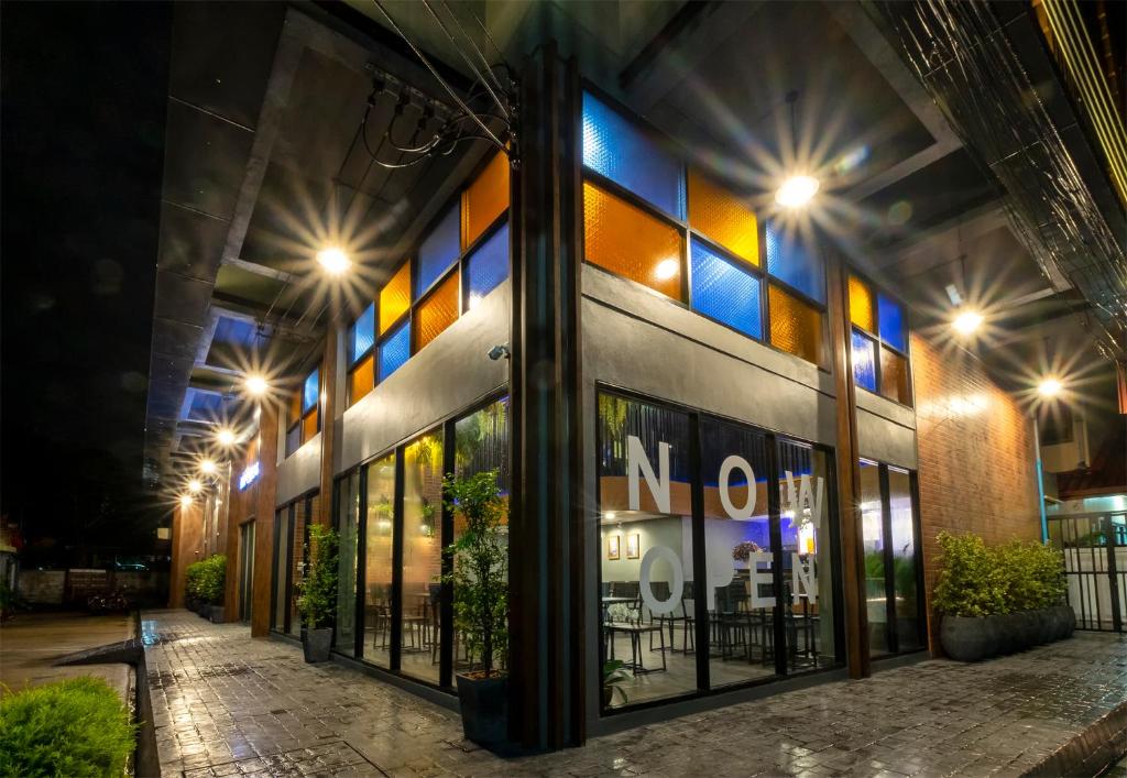 a store front at night with lights on at BED Friends Poshtel in Chiang Rai