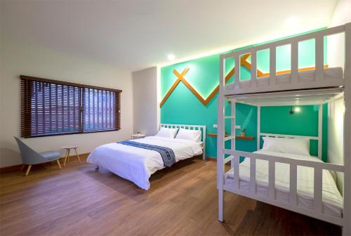 a bedroom with two beds and a bunk bed at BED Friends Poshtel in Chiang Rai