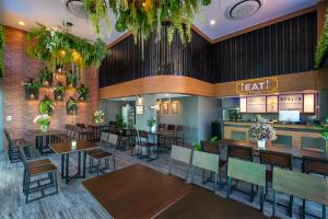 a restaurant with tables and chairs and a cafeteria at BED Friends Poshtel in Chiang Rai