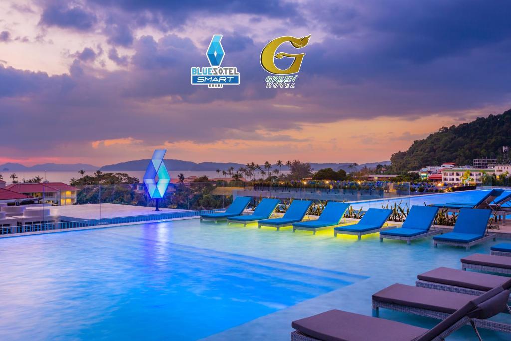 A large swimming pool with blue and yellow lounge chairs at BlueSotel SMART Krabi Aonang Beach - Adults only