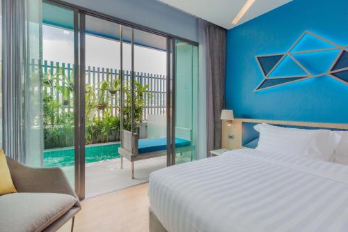 A bedroom with a bed and a view of a pool at BlueSotel SMART Krabi Aonang Beach - Adults only