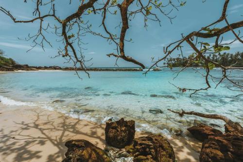 a beach with some rocks and the ocean at Hideout Koh Kood in Ko Kood