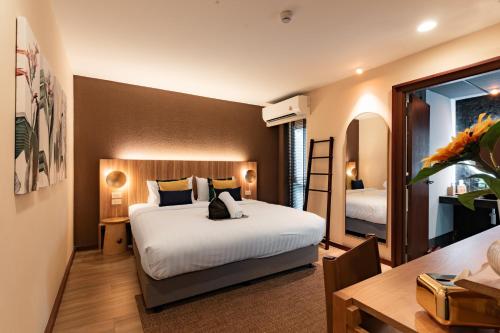a bedroom with a large white bed and a desk at Mybed Chonburi in Ban Nong Tako