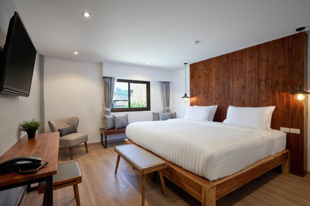 A bedroom with a large white bed and a desk at P2 Wood Loft in Phi Phi Islands