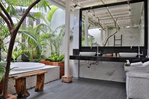 a bathroom with two sinks and a tub with plants at Shantaa Resort, Kohkood in Ko Kood