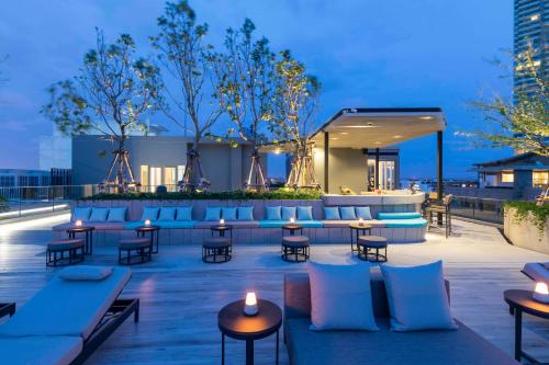 A rooftop patio with couches and tables and lights at U Jomtien Pattaya