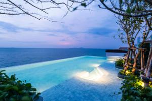 A swimming pool with the ocean in the background at U Jomtien Pattaya