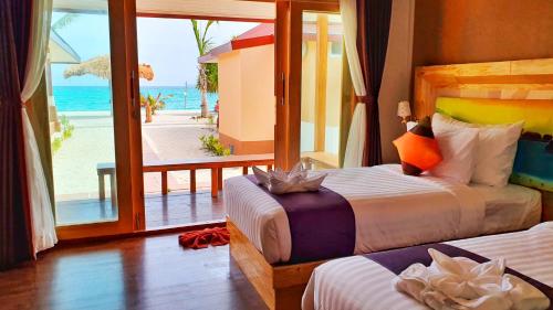 a bedroom with two beds and a view of the ocean at Zodiac Seesun Resort in Koh Lipe