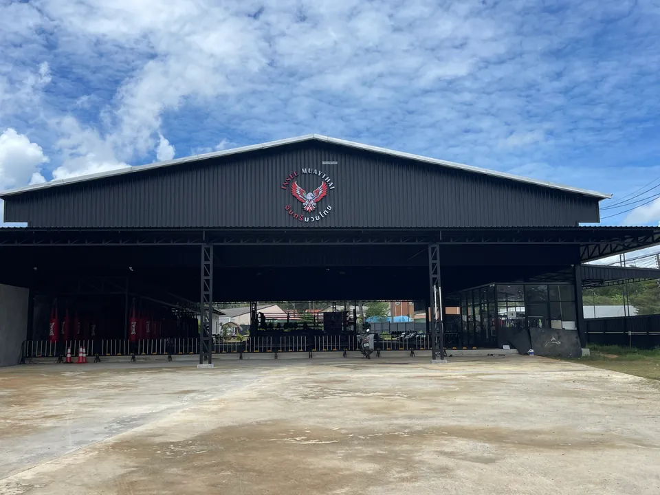 Open-sided Insee Muay Thai training hall with the eagle logo on the gable