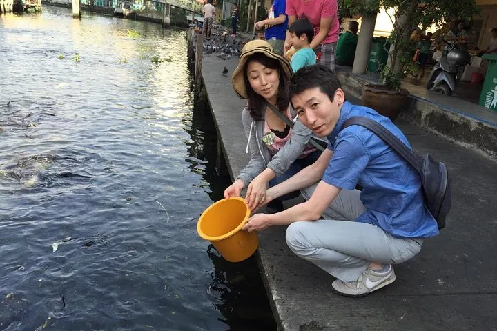 Feeding fish at a temple pier